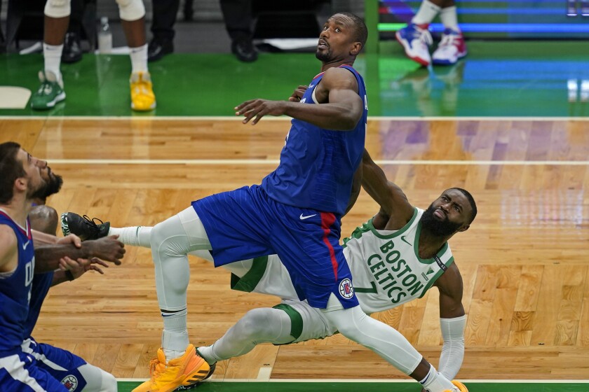 Boston Celtics guard Jaylen Brown (7) falls to the floor after struggling for rebound position with Los Angeles Clippers center Serge Ibaka in the fourth quarter of an NBA basketball game, Tuesday, March 2, 2021, in Boston. The Celtics won 117-112. (AP Photo/Elise Amendola)