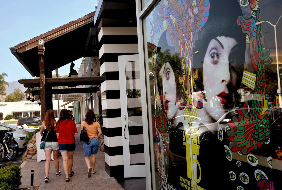 Shoppers walk past Sephora, a chain of perfume and cosmetic stores, at the Malibu Village.