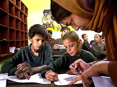 10-yr-old Hasan (C) gets a drawing lesson from teacher Nasreen Yousaf at a day shelter run by the U.S. funded Save The Children organization in Quetta, Pakistan.