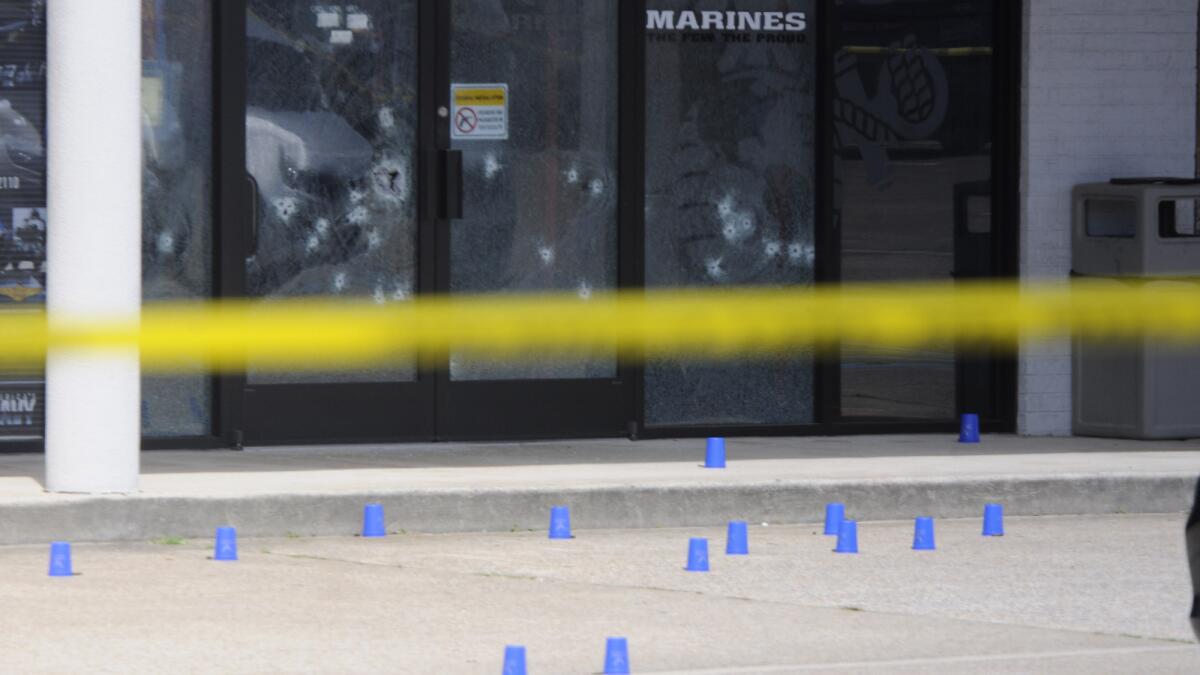 Blue shell-casing markers are scattered outside the military recruiting center, where the attack began.