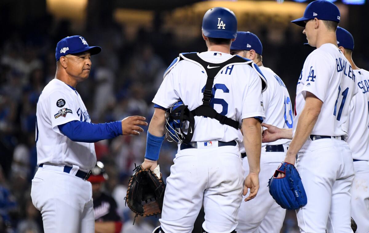 Dodgers manager Dave Roberts pulls pitcher Walker Buehler, right, out of the game in Game 5 of the NLDS at Dodger Stadium on Wednesday.