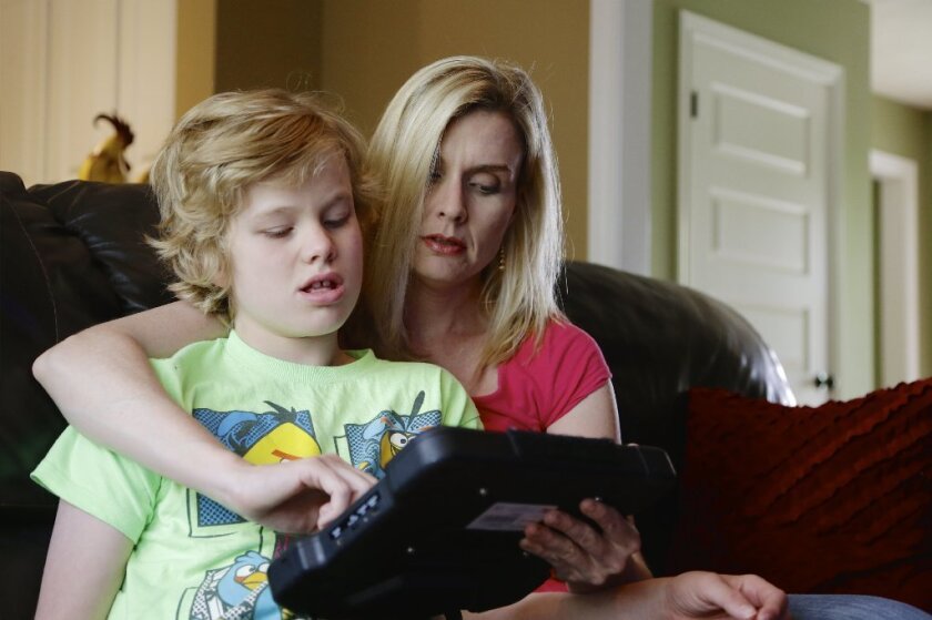 Colleen Jankovich of Omaha works with her son Matthew, who has autism and requires 24-hour care. A study in JAMA Pediatrics says the lifetime cost of caring for people with autism is between $1.43 million and $2.44 million.