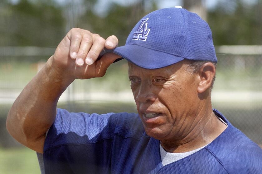 Dodgers bunting and base running coordinator Maury Wills adjusts his cap during spring training at Dodgertown