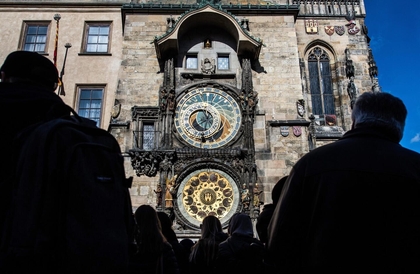 epa04645886 People observe medieval Astronomical clock at Old Town Hall Tower at the Old Town Square in Prague, Czech Republic 03 March 2015. The astronomical clock of Prague's town hall was built in 1410 by royal clockmaker Mikulas of Kadan and the rector of Prague University, Master Jan Sindel. It was the first time in central Europe that such a large astronomical clock was placed on the facade of a secular building. Fitted with an astronomical dial, it was enhanced with a calendar dial at the end of the 15th century. EPA/FILIP SINGER ** Usable by LA, CT and MoD ONLY **