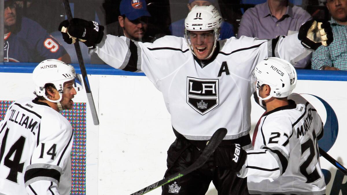 Kings center Anze Kopitar, middle, celebrates with teammates Justin Williams, left, and Alec Martinez after scoring the winning goal against the New York Islanders on Thursday.