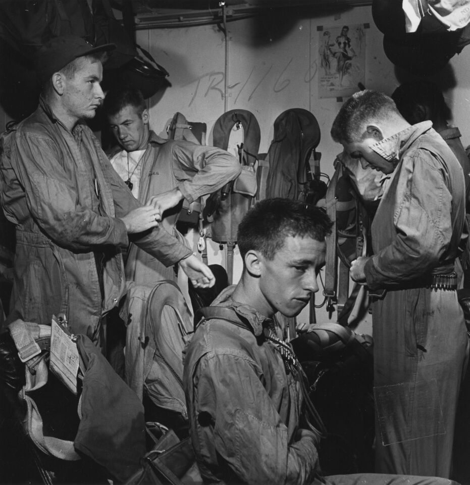 Veteran aircrewmen put on flight gear for a strike against Manila, November 1944. Sober faces show that they know what they are up against.