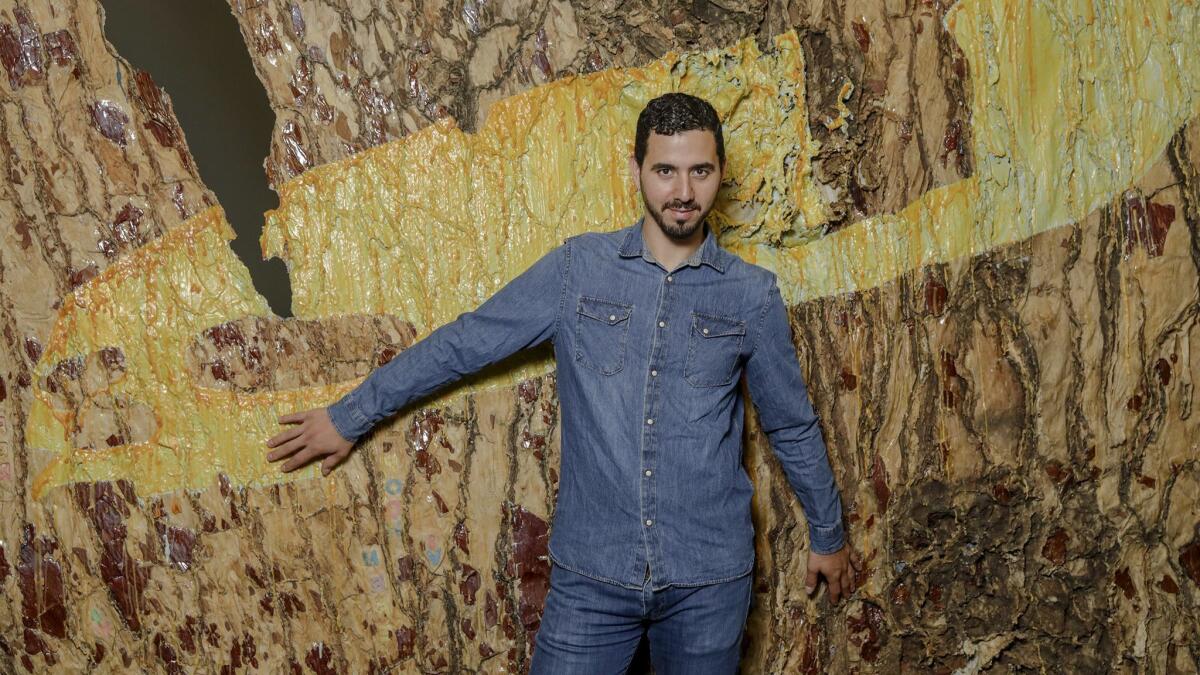 Eddie Rodolfo Aparicio stands by his artwork "Holbein en Crenshaw," part of the exhibition "My Veins Do Not End in Me" at the Mistake Room in L.A.