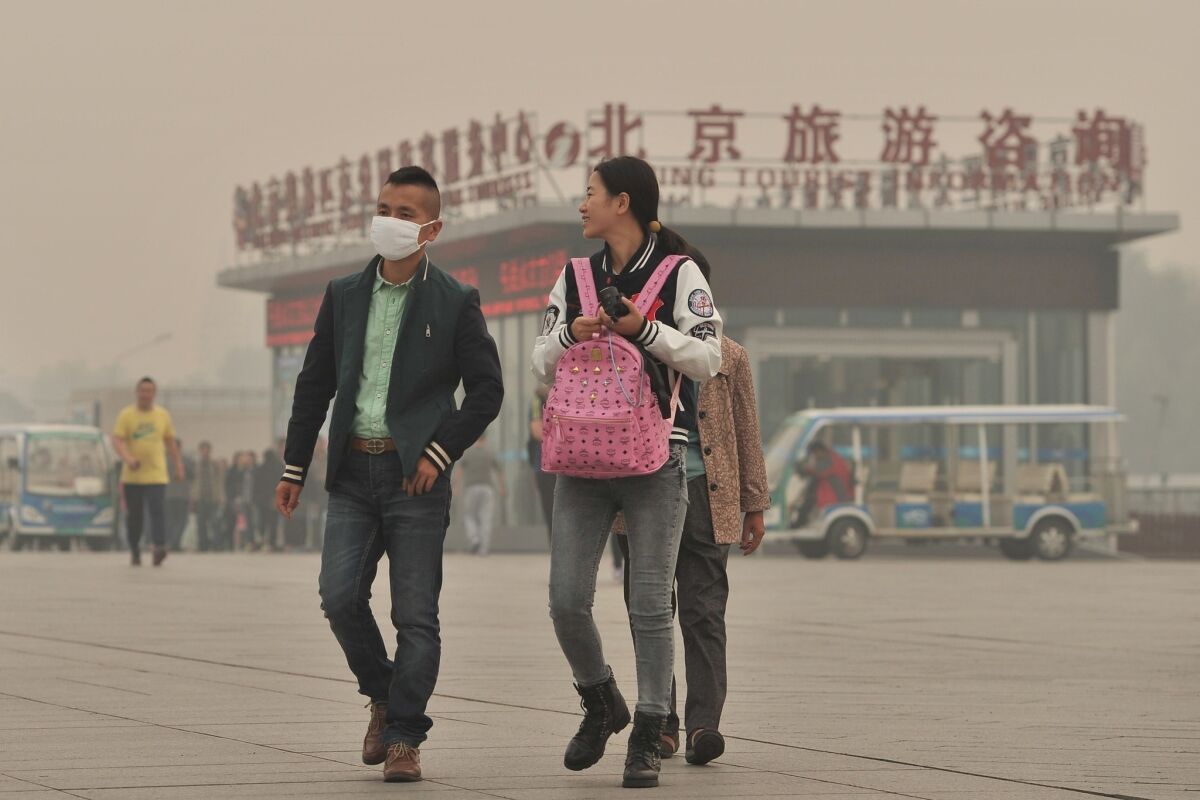 A masked man walks by the National Stadium in Beijing amid heavy smog.