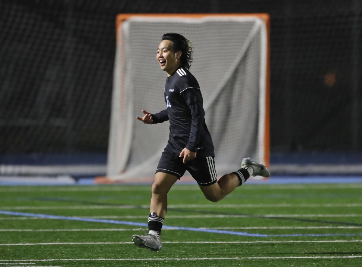 Corona del Mar's Ari Kanazawa runs to the sidelines to celebrate a goal with teammates during the Battle of the Bay.