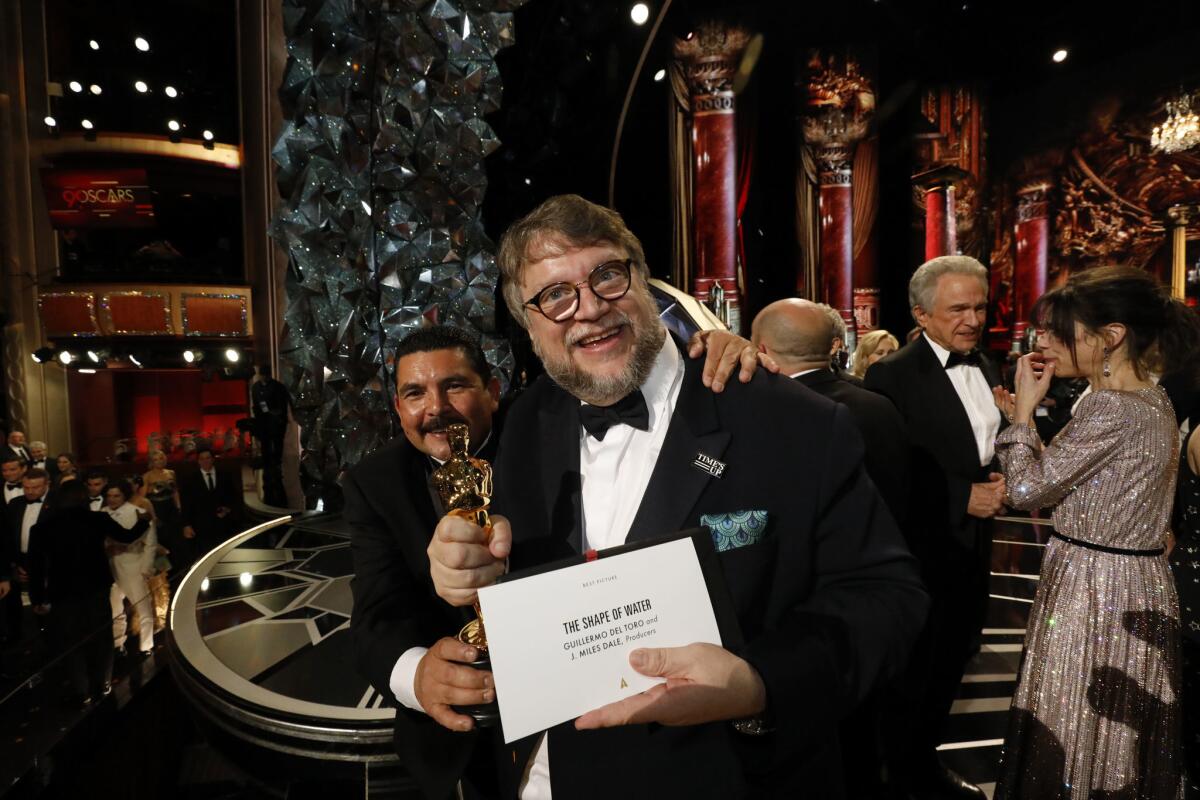 The two Guillermos: Director and best picture winner Guillermo Del Toro, with "Jimmy Kimmel Live's" Guillermo Rodriguez. Del Toro, leaving nothing to chance, shows the best picture envelope.