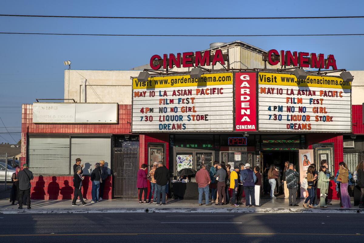 GARDENA, CA-MAY 10, 2023: People gather outside the Gardena Cinema in Gardena, before a screening of the movie, "Liquor Store Dreams," part of the Los Angeles Asian Pacific Film Festival. The community is rallying around the theater as its owner ponders its future. (Mel Melcon / Los Angeles Times)