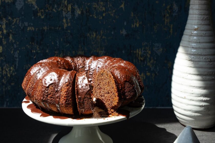 The bundt cake is coated with a chocolate glaze.