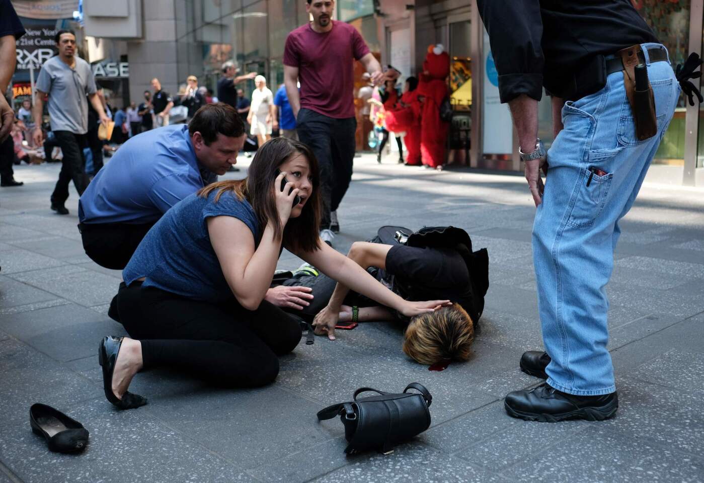 People attend to an injured man after a car plowed into Times Square in New York and struck several people.