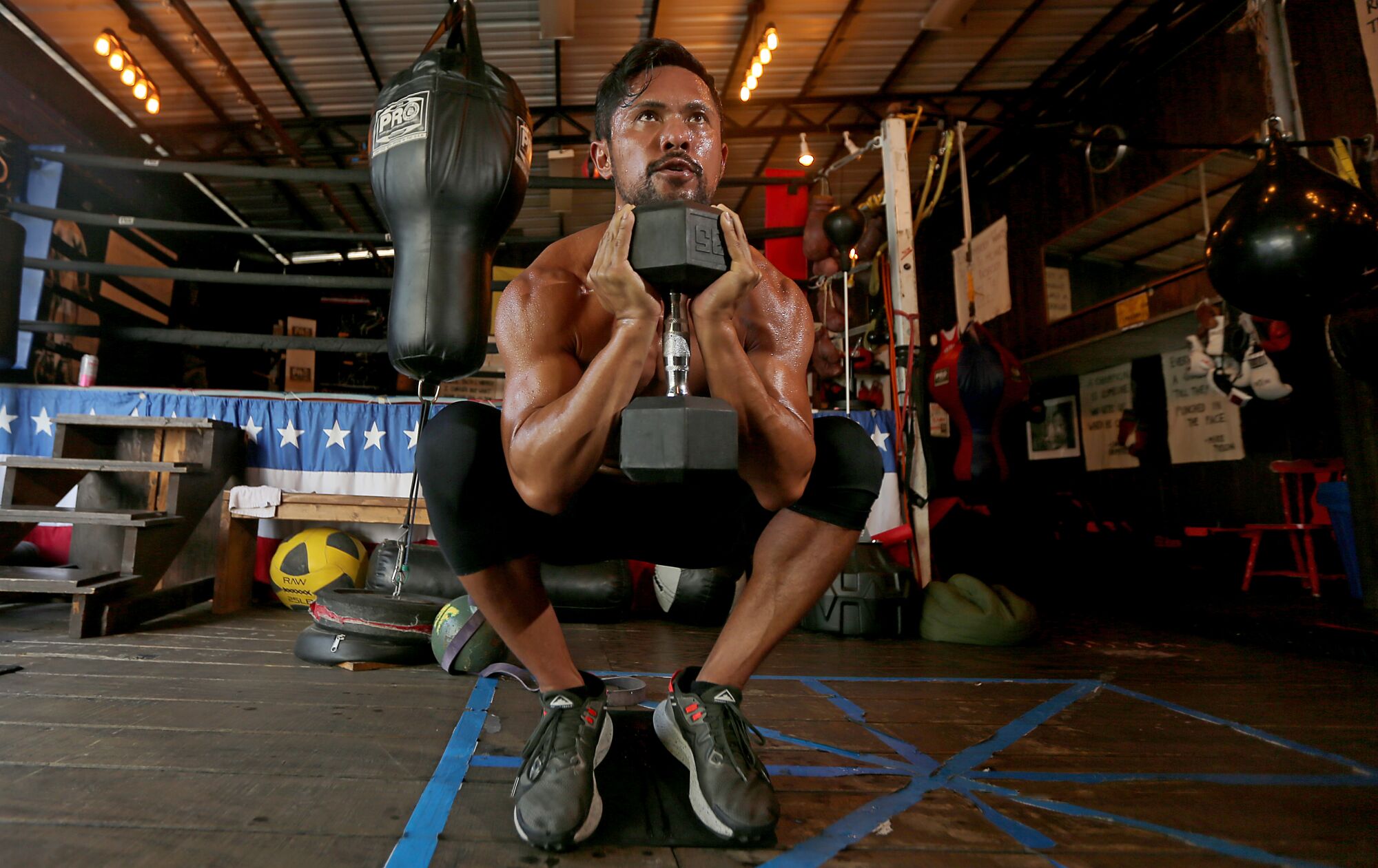 Joel Relampagos squatting while holding a heavy weight