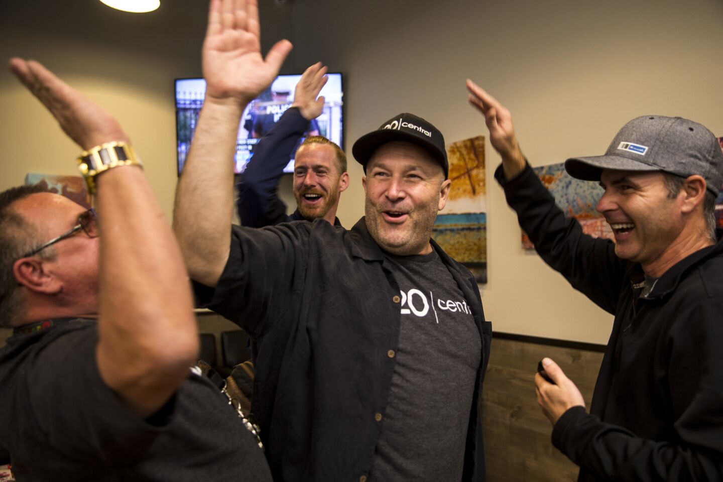 Robert Taft Jr., center, founder of the medical marijuana dispensary 420 Central in Santa Ana, high-fives workers Sunday. “Being part of history is an amazing thing,” he says.