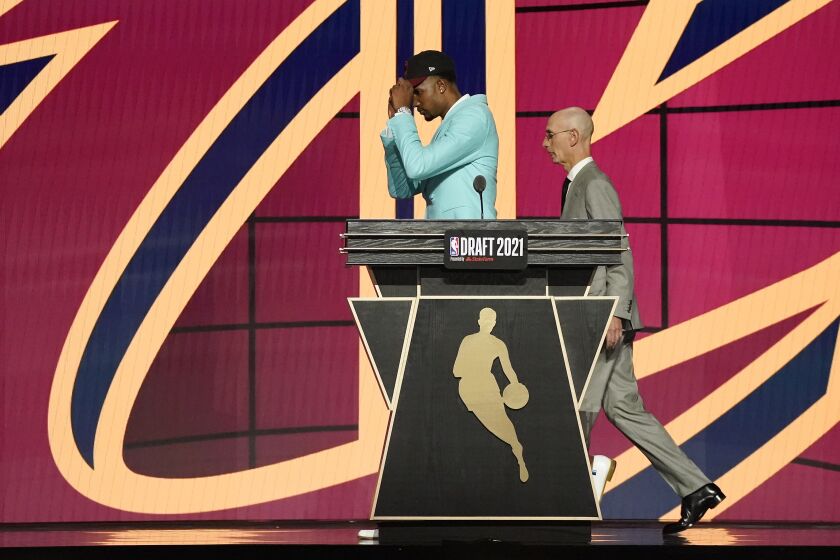 Evan Mobley walks off the stage with NBA Commissioner Adam Silver after being selected third overall by the Cleveland Cavaliers during the NBA basketball draft, Thursday, July 29, 2021, in New York. (AP Photo/Corey Sipkin)