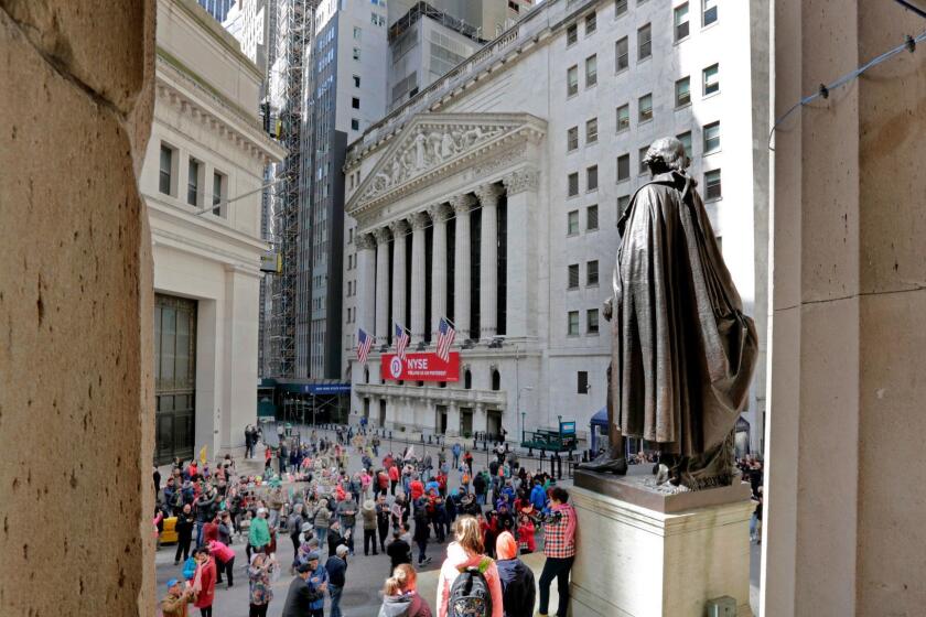 FILE- In this April 5, 2018, file photo, a statue of George Washington, on the steps Federal Hall, overlooks the New York Stock Exchange. The U.S. stock market opens at 9:30 a.m. EDT on Monday, April 16. (AP Photo/Richard Drew, File)
