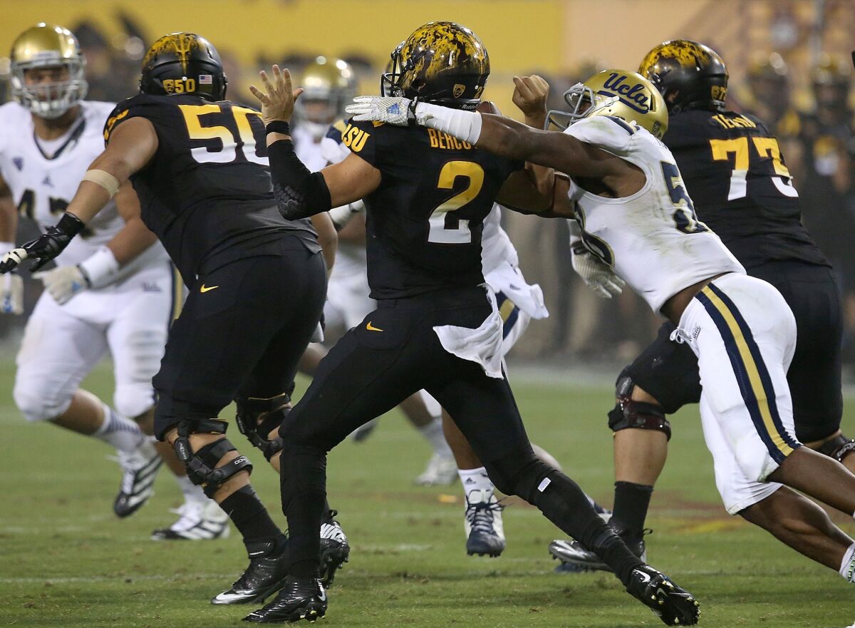 Bruins linebacker Deon Hollins strips the ball from Sun Devils quarterback Mike Bercovici in the third quarter.