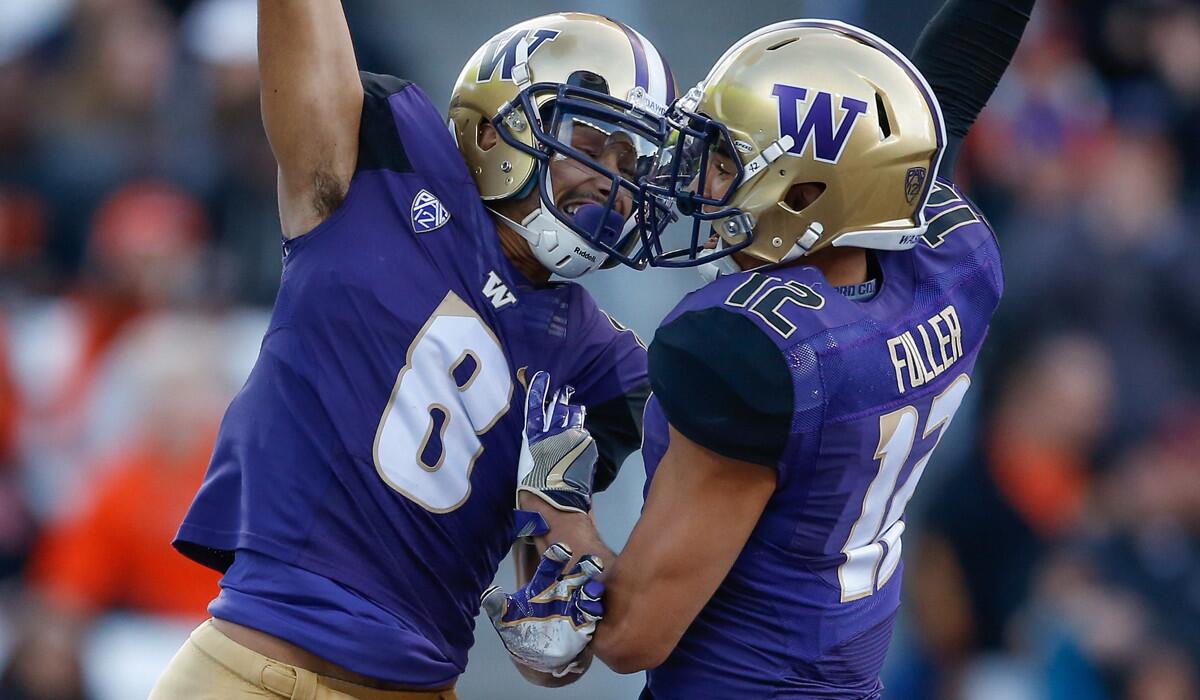 Washington wide receiver Dante Pettis, left, is congratulated by teammate Aaron Fuller after scoring a touchdown against Oregon State in the first half Saturday.