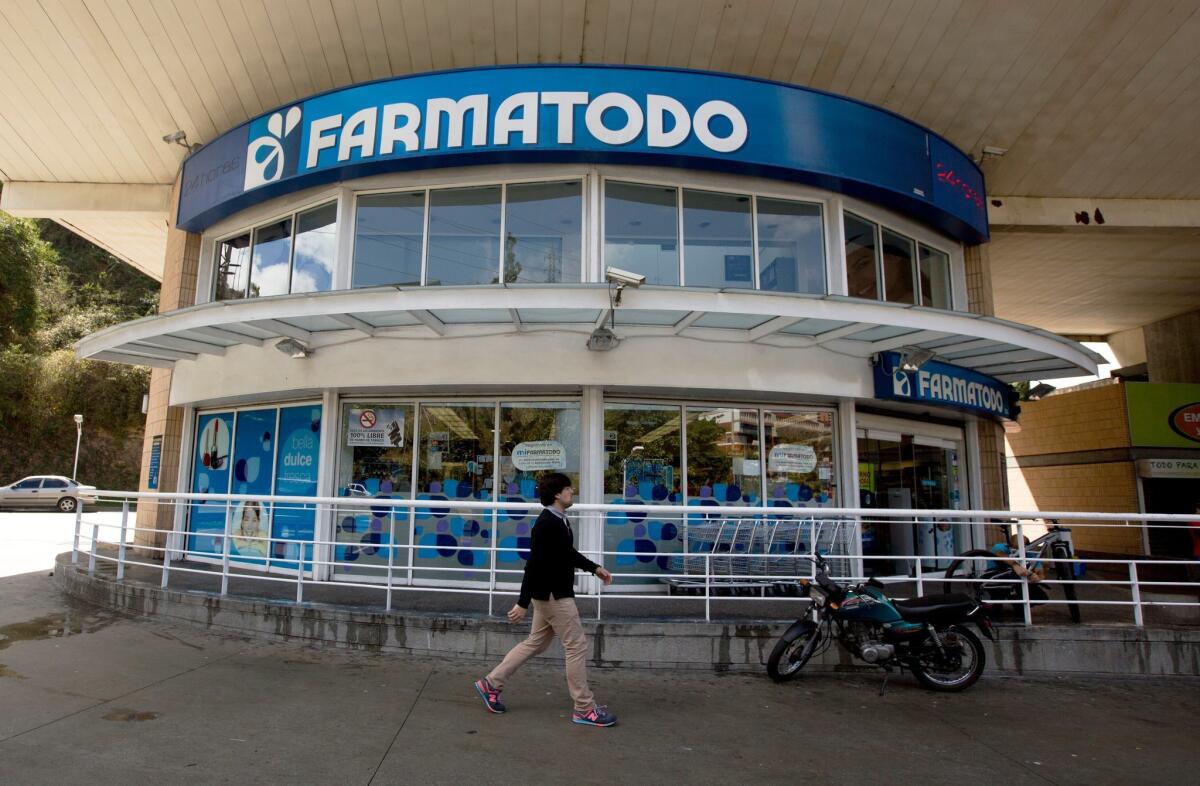 A pedestrian walks past a Farmatodo pharmacy in Caracas, Venezuela, on Monday.