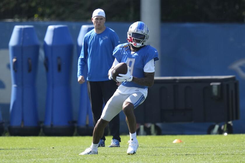 Detroit Lions receiver Jameson Willams catches as assistant wide receivers coach Seth Ryan watches during an NFL football practice, Tuesday, Oct. 3, 2023, in Allen Park, Mich. Williams was expected to speak to reporters for the first time since the NFL reduced his suspension for gambling. (AP Photo/Carlos Osorio)