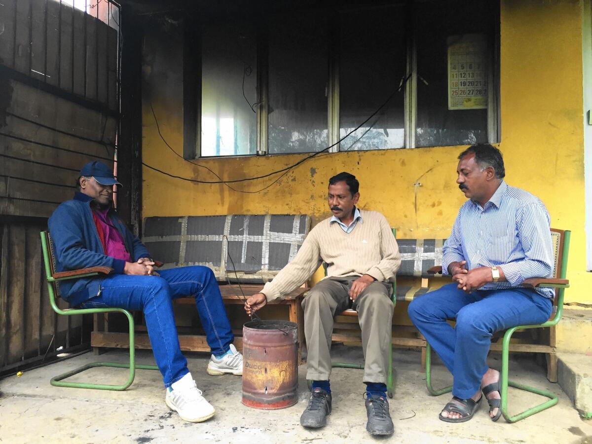 Roy Rolen, left, with other security guards outside the Hindustan Photo Films factory in India. “We’re tired of sitting here all day and telling the same old stories about those golden years. That is over and it’s time to get out,” Rolen says.