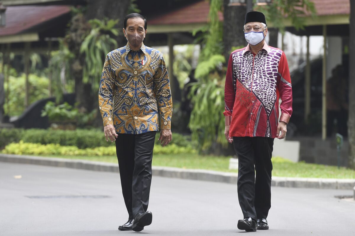 In this photo released by Indonesian Presidential Palace, Indonesian President Joko Widodo, left, walks with Malaysian Prime Minister Ismail Sabri Yaakob during their meeting at Merdeka Palace in Jakarta, Indonesia, Friday, April 1, 2022. (Indonesian Presidential Palace via AP)