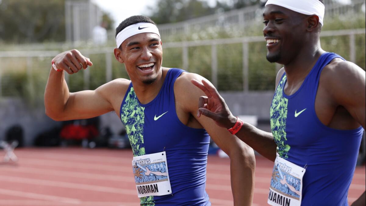 Michael Norman, left, and Rai Benjamin share a light moment after their epic 400-meter race at the Mt. SAC Relays on Saturday.