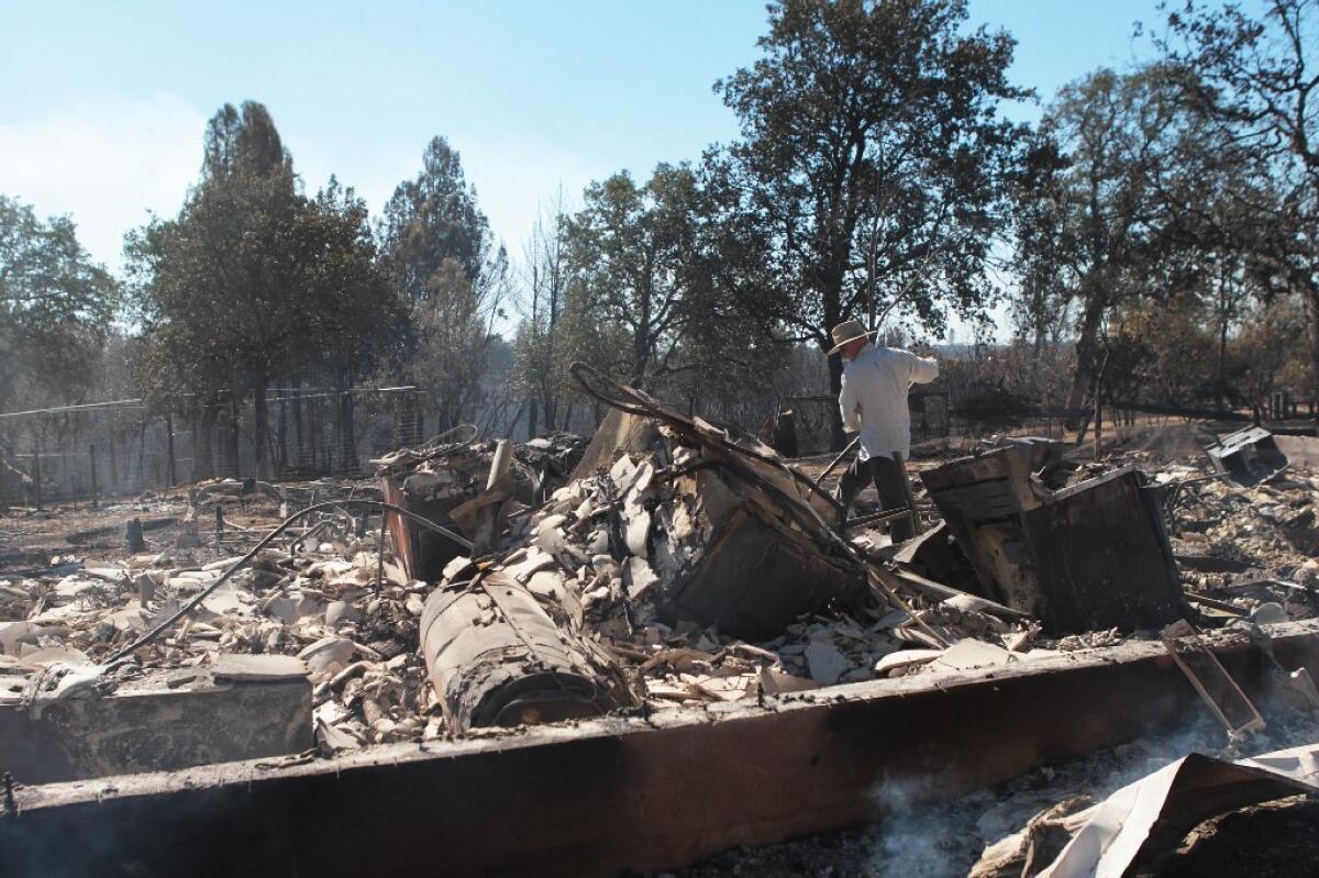 Carl Reed helps his son-in-law, Sean Reed, go through the remnants of his home off Small Farms Drive on Tuesday after the Clover fire scorched the area.