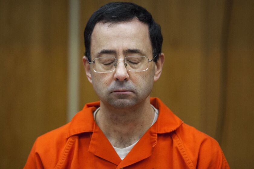 FILE - In this Feb. 5, 2018, file photo, Larry Nassar listens during his sentencing at Eaton County Circuit Court in Charlotte, Mich. Crimes of sexual abuse committed by Nassar and the chaos they provoked have been named the Story of the Year in balloting by Associated Press members and editors. (Cory Morse/The Grand Rapids Press via AP, File)