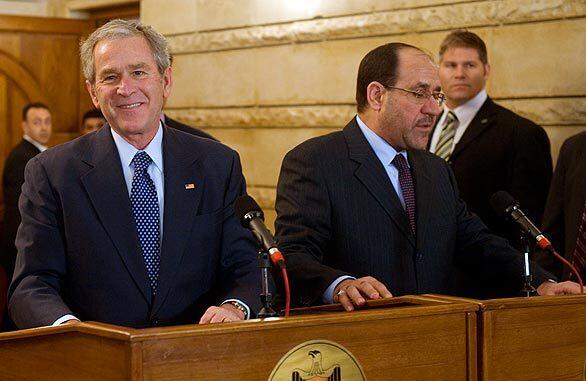 President Bush, alongside Iraq Prime Minister Nouri Maliki, is apparently unruffled and has a smile for reporters after ducking two thrown shoes at a news conference.