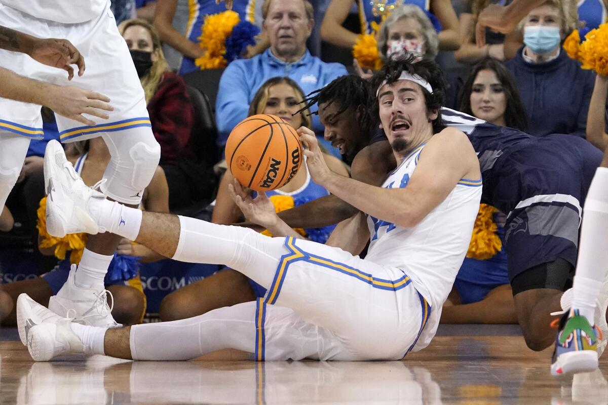 UCLA guard Jaime Jaquez Jr., right, grabs a loose ball away from North Florida guard Jarius Hicklen