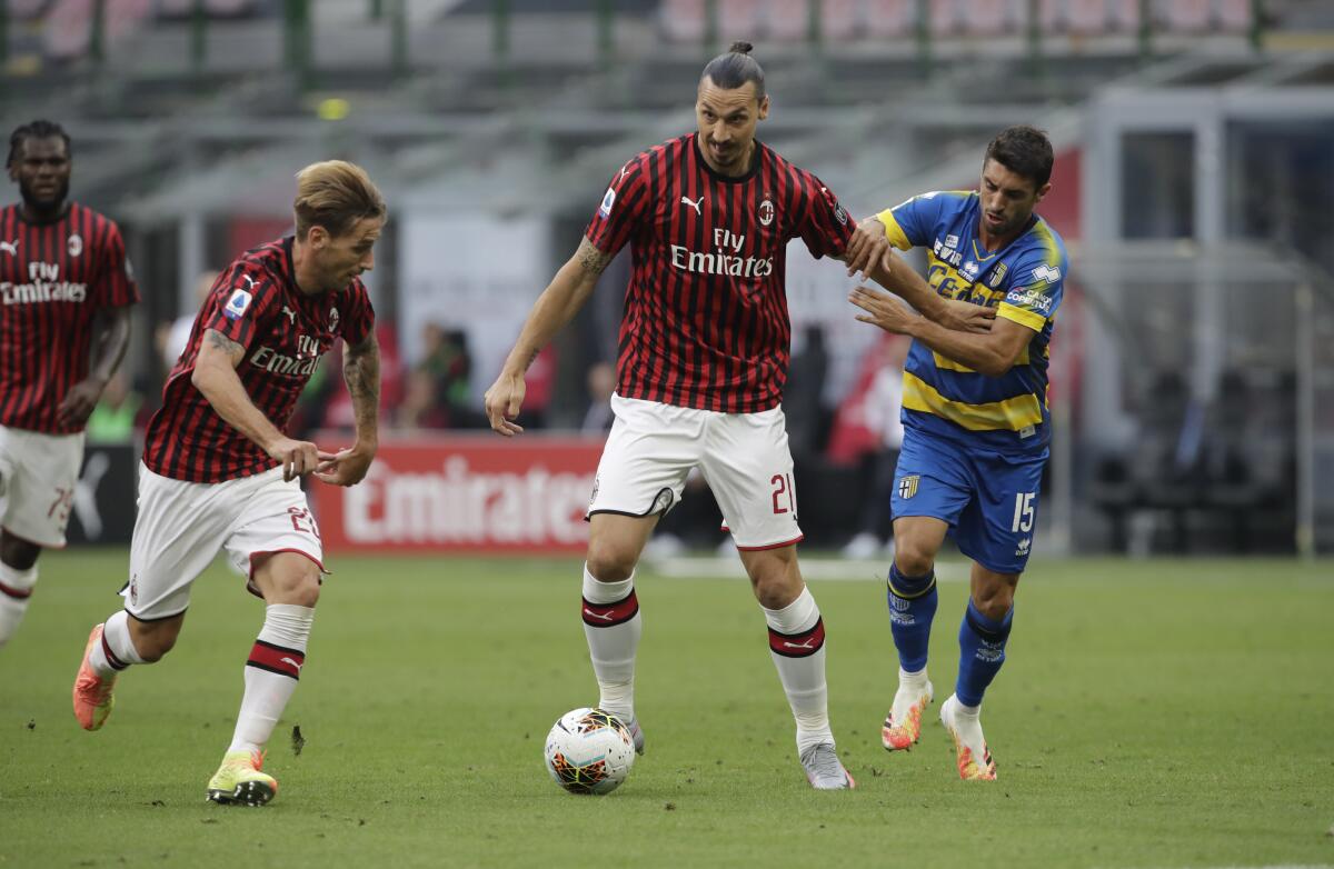 AC Milan's Zlatan Ibrahimovic fights for the ball with Parma's Gaston Brugman.