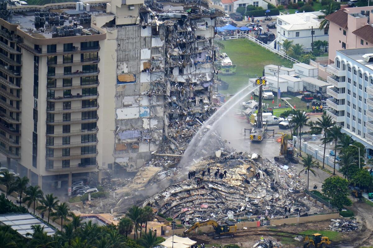 FILE - In this June 25, 2021, file photo, rescue personnel work at the remains of the Champlain Towers South condo building in Surfside, Fla. A private bidder is willing to offering up to $120 million to purchase the Miami-area oceanfront property where the collapsed Champlain Towers South building once stood. The offer was revealed Wednesday, Aug. 12, during a hearing before Circuit Judge Michael Hanzman. AP Photo/Gerald Herbert, File)