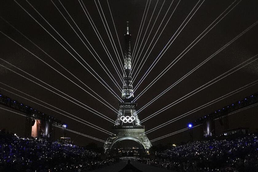 A light show is projected from the Eiffel Tower in Paris, France, during the opening ceremony of the 2024 Summer Olympics, Friday, July 26, 2024. (AP Photo/David J. Phillip)