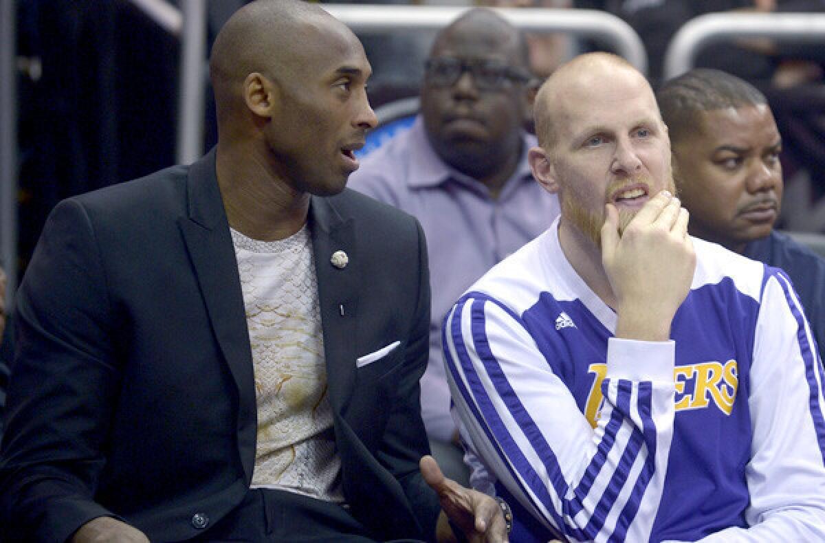 Lakers guard Kobe Bryant talks to center Chris Kaman during the first half of a game against the Magic on Friday in Orlando.