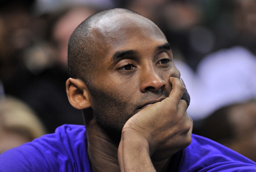Lakers forward Kobe Bryant watches from the bench during the first half of a game against the Grizzlies.