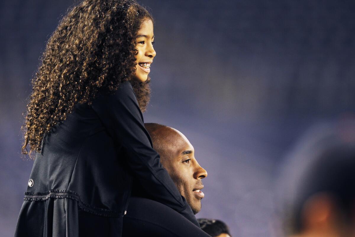 Kobe Bryant holds his daughter Gianna on his shoulders. 