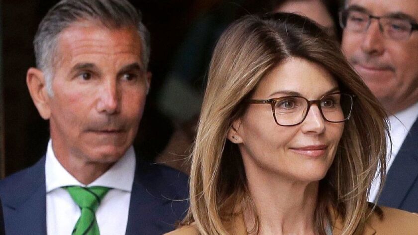Lori Loughlin and husband Mossimo Giannulli, left, depart federal court in April.