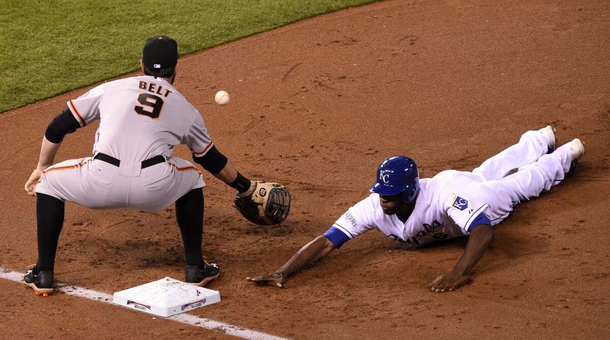 The Kansas City Royals' Lorenzo Cain, right, jumps back to first as San Francisco Giants first baseman Brandon Belt (9) waits for the pickoff attempt in the first inning of Game 6 of the World Series at Kauffman Stadium in Kansas City, Mo., on Tuesday. The Royals won, 10-0, to force a Game 7.