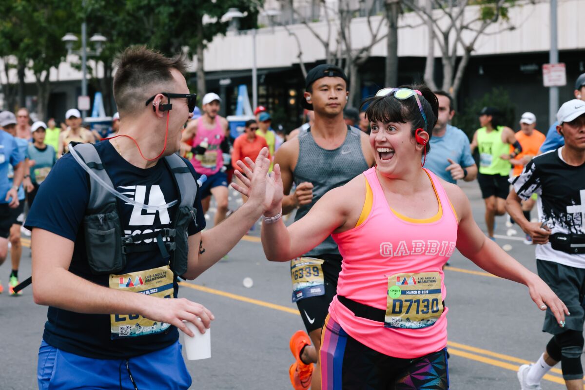 Two runners exchange a high five during the L.A. Marathon.
