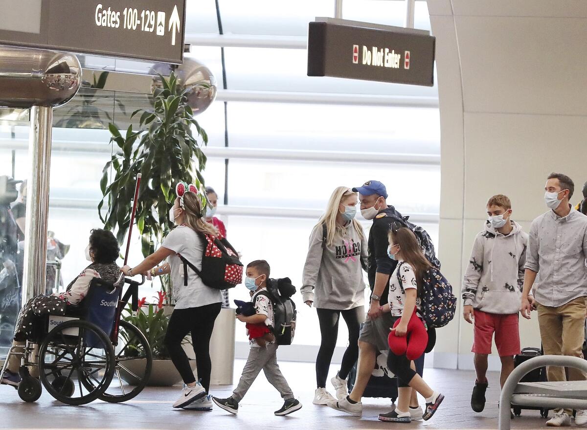 A line of travelers inside an airport.