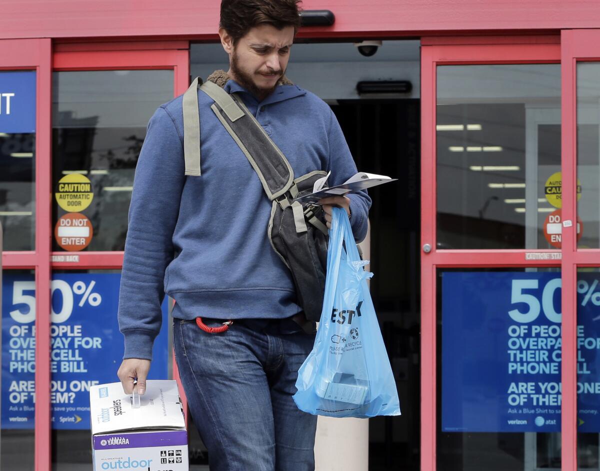A shopper carries his bags from a Miami store on Feb. 9.