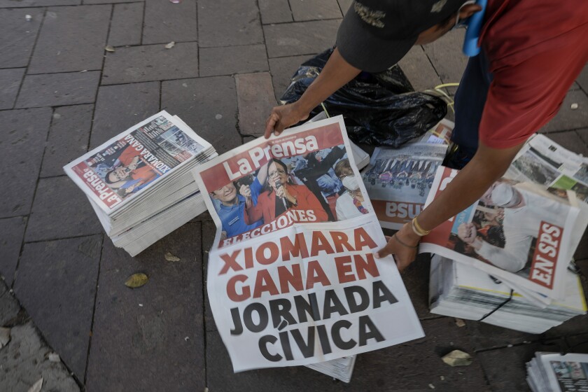 Un hombre muestra un cartel con una foto de la candidata presidencial del Partido Libre, Xiomara Castro