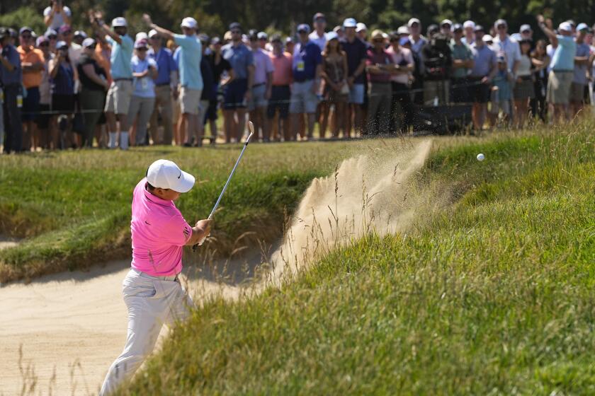 Tom Kim hits from the bunker on the 15th hole during the third round of the U.S. Open golf tournament.