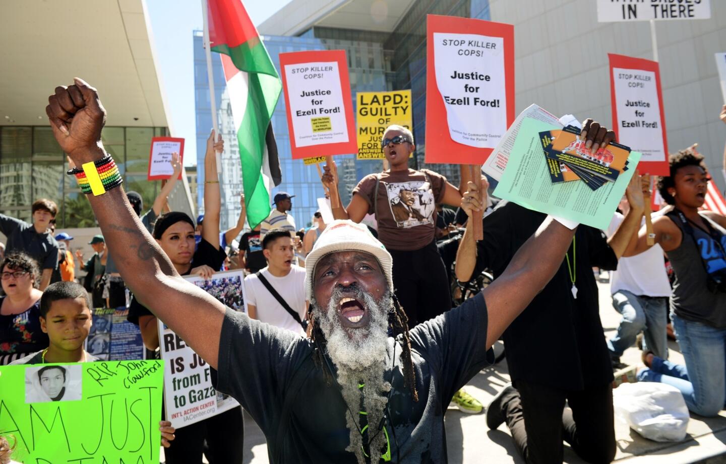 Kelly Kunta leads a rally outside Los Angeles Police Department headquarters in downtown L.A. on Sunday to protest police killings of young black men around the country.