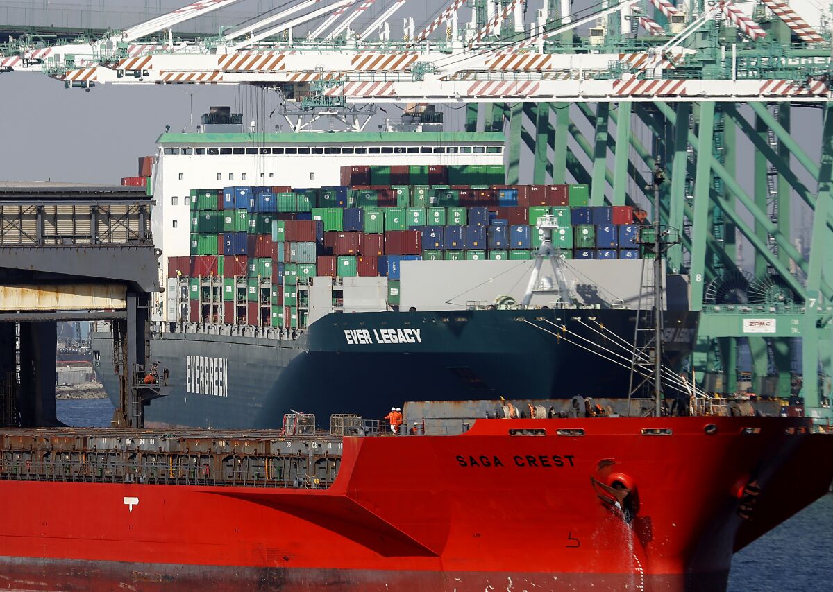 Crewmen stand at the bow of a cargo ship in the Port of Los Angeles.