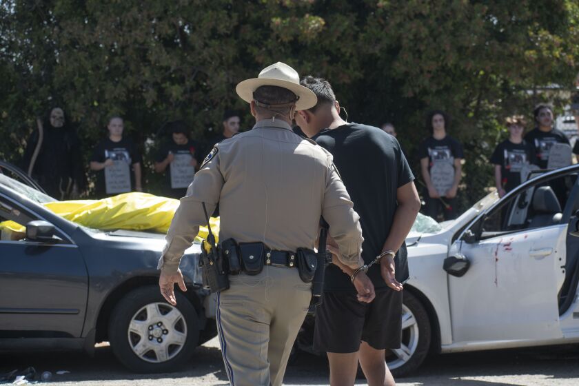 Senior Favian Lopez being taken into custody after mock DUI accident in Every 15 Minutes event at Ramona High School.