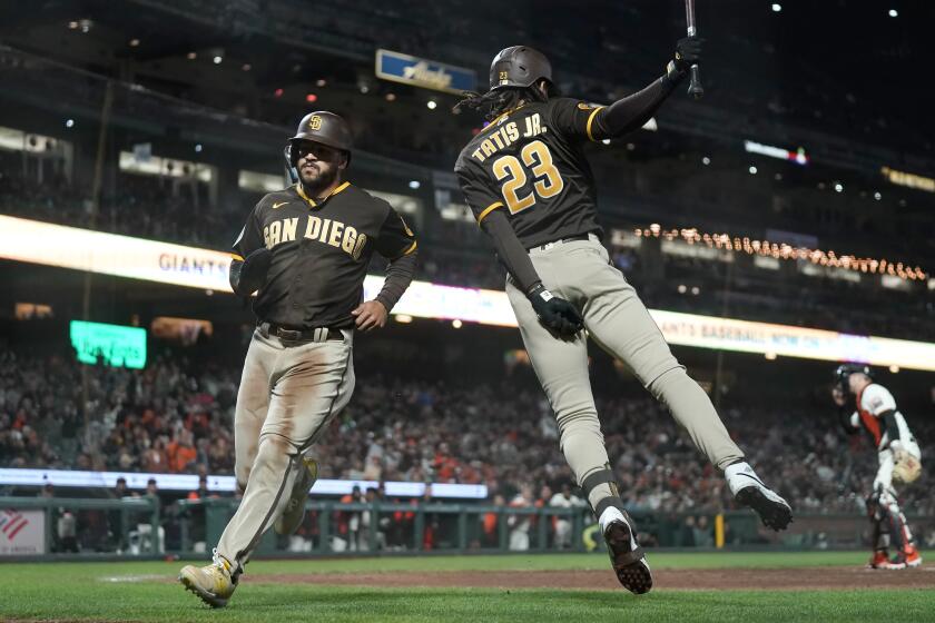 San Diego Padres' Trent Grisham, left, runs toward Fernando Tatis Jr. (23) after scoring against the San Francisco Giants during the 10th inning of a baseball game in San Francisco, Wednesday, Sept. 27, 2023. (AP Photo/Jeff Chiu)