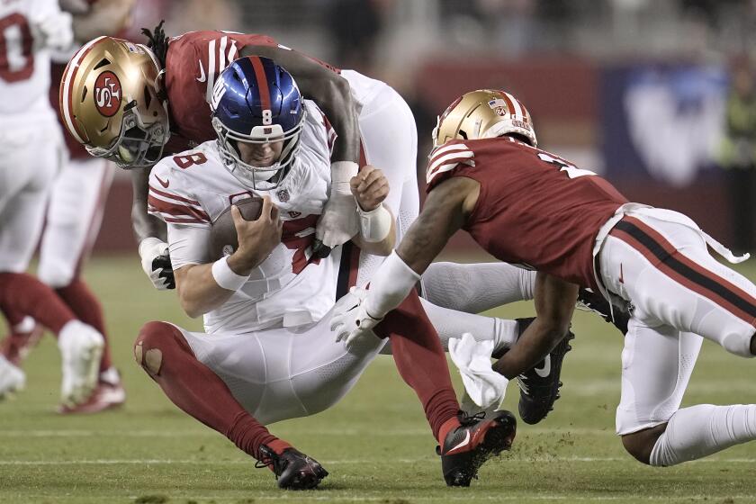 New York Giants quarterback Daniel Jones (8) is tackled by San Francisco 49ers defensive tackle Javon Kinlaw, top, and cornerback Deommodore Lenoir during the second half of an NFL football game in Santa Clara, Calif., Thursday, Sept. 21, 2023. (AP Photo/Godofredo A. Vásquez)